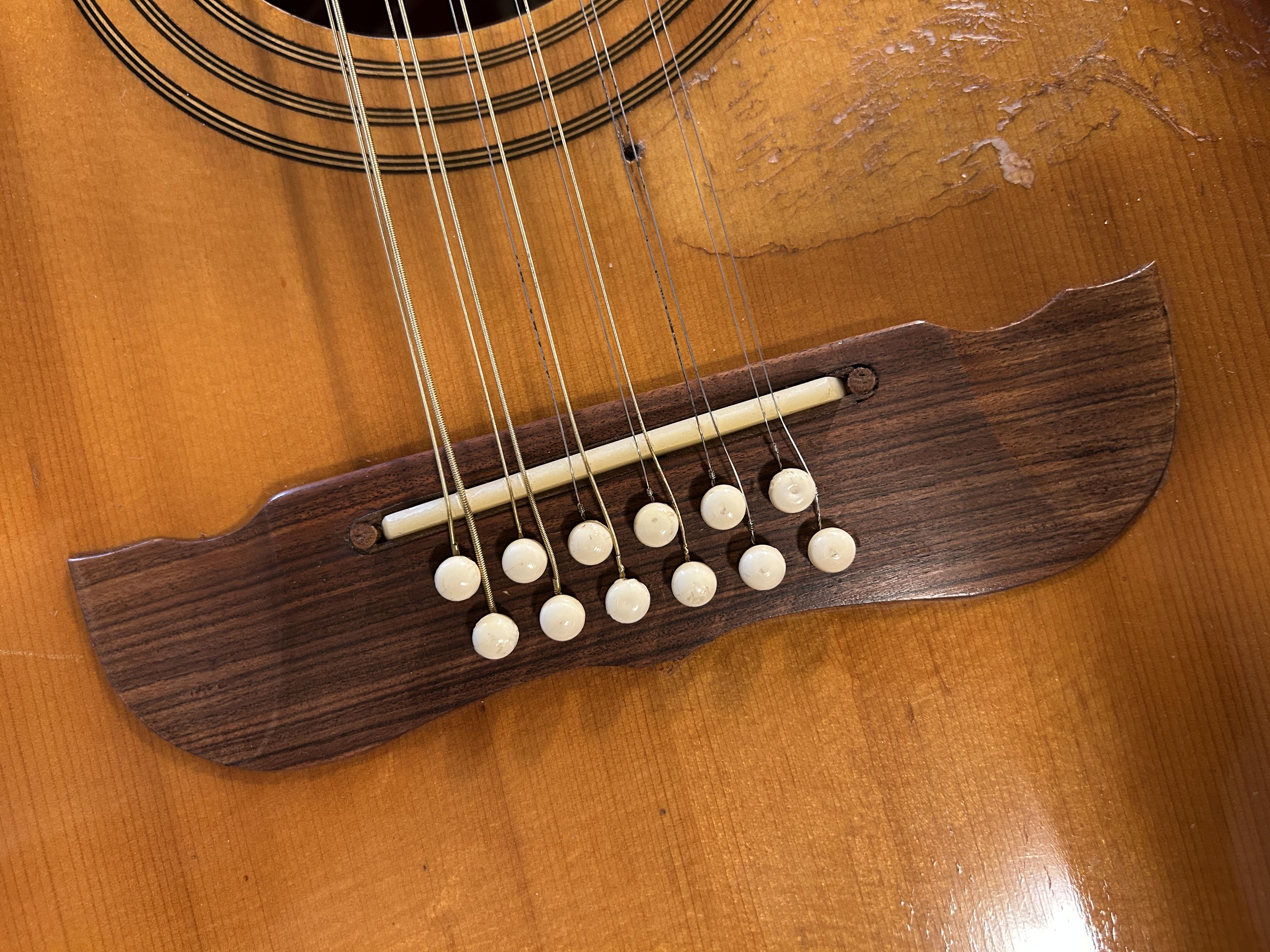 one of the problems of downsizing a guitar. it’s the bridge, saddle and strings of the 12 string project with the forward (octave string) bridge pins interfering with the other six strings. The before picture so far, but the after picture may not be perfect either. 😀😇🎶